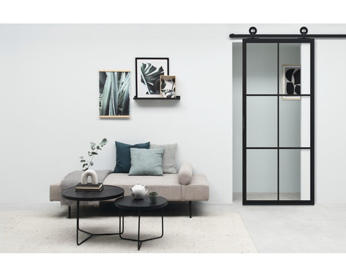 Wohnzimmer mit Tagesbett, Couchtischen und Schiebetür im Industriedesign