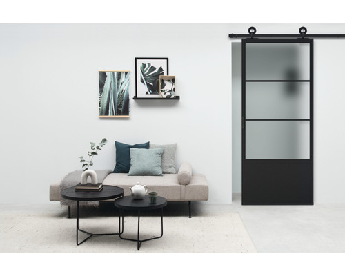 Salon avec lit de jour, table basse et porte coulissante en verre