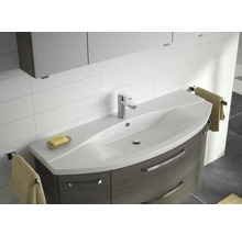 Waschbecken mit Unterschrank, Armatur und Handtüchern in einem Badezimmer