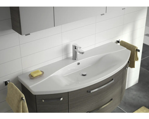 Waschbecken mit Unterschrank, Armatur und Handtüchern in einem Badezimmer