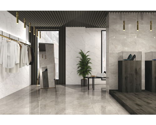 Pièce lumineuse avec carrelage en marbre, vêtements, miroir et chaussures dans des vitrines