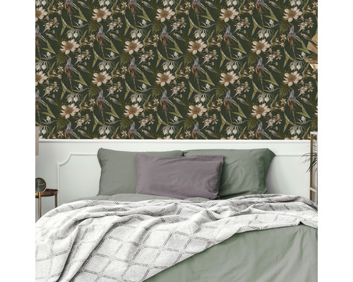 Chambre avec papier peint à motifs floraux et lit avec oreillers et couverture