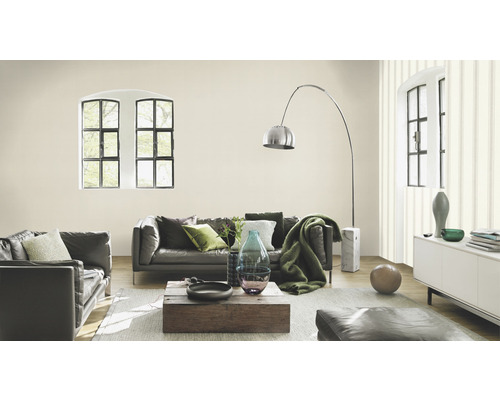 Salon lumineux avec canapé en cuir, table en bois et grandes fenêtres.