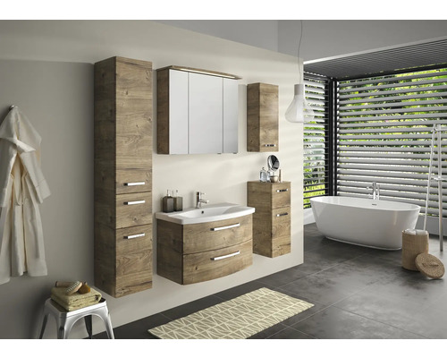 Badezimmer mit Waschtisch, Spiegelschrank, Hochschrank, Unterschrank und Badewanne in einem hellen Raum