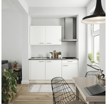 Cuisine compacte avec armoires blanches, hotte aspirante et plan de travail gris dans une pièce lumineuse.