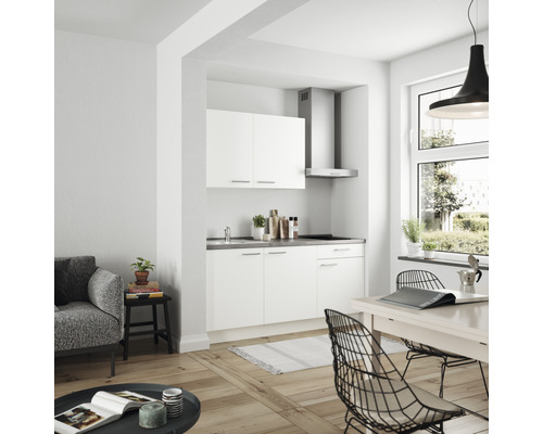 Cuisine linéaire claire dans un espace de vie aménagé de façon moderne avec table à manger et sièges.