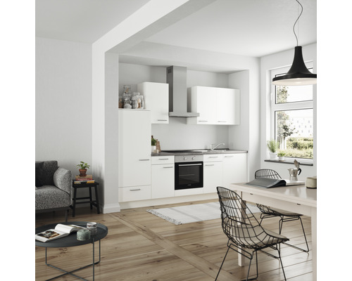 Cuisine claire avec kitchenette, armoires murales, hotte aspirante et table à manger dans un espace de vie moderne.