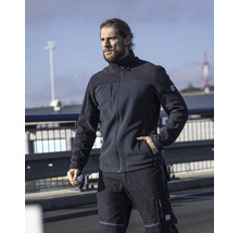 Un homme porte des vêtements de travail : veste en polaire et pantalon de travail