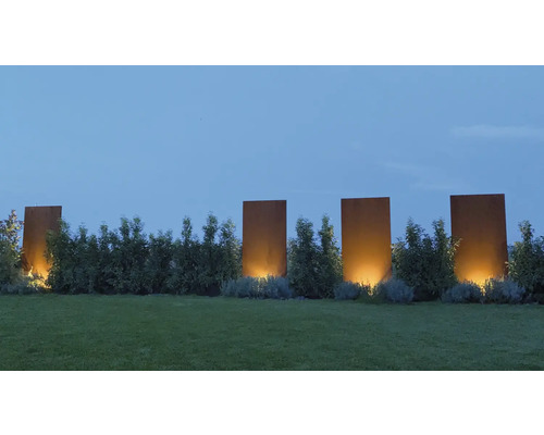 Gartenlandschaft mit Rasenfläche, Hecken und dekorativen Stahlplatten