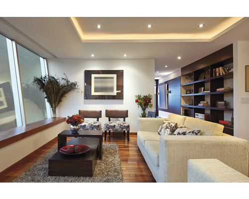 Salon avec canapé, fauteuils, tables basses et étagères