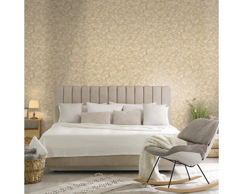 Schlafzimmer mit Bett, Kissen, Decke, Sessel und dekorativer Wandgestaltung