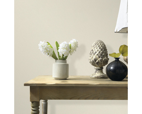 Dekorative Elemente auf einem Holztisch vor einer Wand.