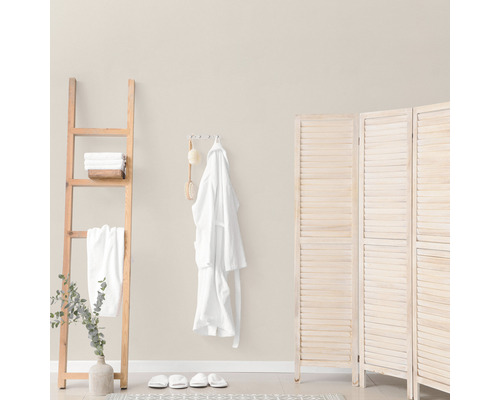 Salle de bain lumineuse avec échelle en bois, peignoir et paravent