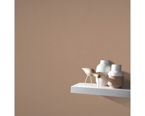 Nahaufnahme einer Wand mit Rauputzstruktur und Dekorationsgegenständen auf einem Regal