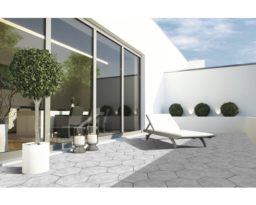 Terrasse avec dalles de béton hexagonales, chaise longue et bacs à plantes