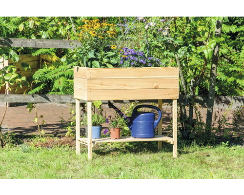 Jardinière sur pieds en bois avec étagère et fleurs plantées dans le jardin.