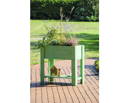 Jardinière surélevée en bois avec plantes et hôtel à insectes dans le jardin