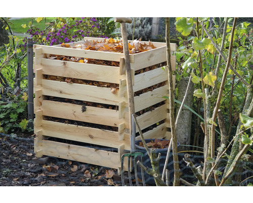 Composteur en bois avec feuilles d''automne et fourche de jardin.