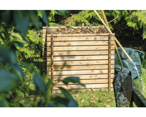 Holzkomposter im Garten mit Gartenwerkzeug