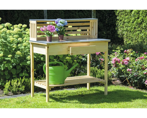 Table de jardin en bois avec tiroir, étagère et fleurs sur le plan de travail