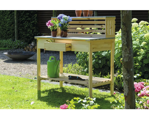 Table de jardin en bois avec tiroir, étagère et plantes sur le plan de travail
