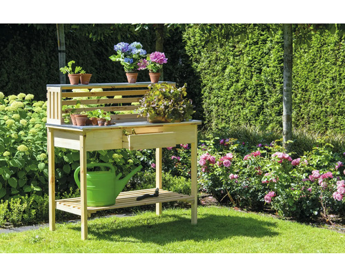Table de rempotage en bois avec tiroir, étagère et plantations dans le jardin