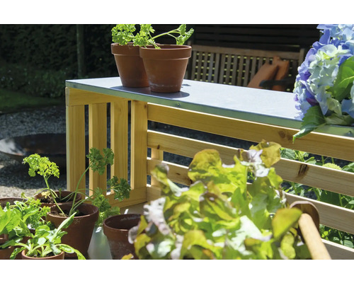 Scène de jardin avec herbes aromatiques, salade et table de jardin en bois.