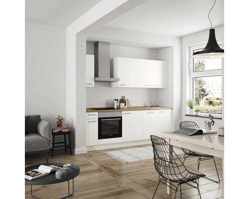 Helle Küche mit weißen Schränken, Dunstabzugshaube und Holzarbeitsplatte in einem modernen Wohnraum.