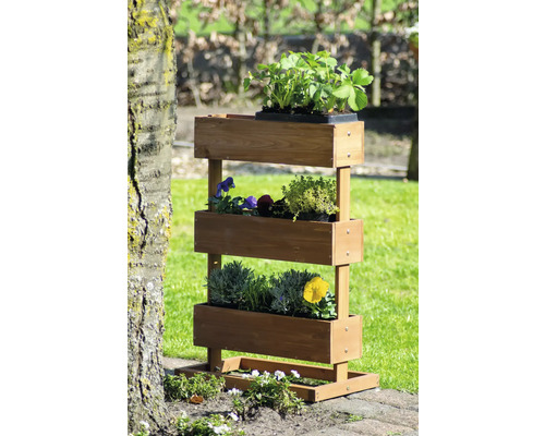 Étagère à herbes aromatiques à trois niveaux en bois avec des plantes dans le jardin