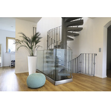 Heller Eingangsbereich mit Wendeltreppe, Pflanze im Topf und Sitzhocker