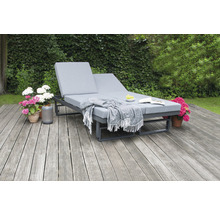 Double chaise longue en métal avec coussin et couverture dans le jardin sur une terrasse en bois