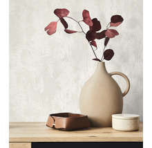 Dekorative Anordnung mit Vase, Zweigen und Aufbewahrungsboxen auf einem Tisch.