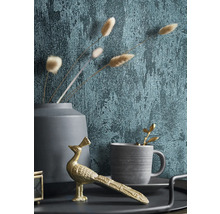 Dekoratives Stillleben mit Tapete, goldener Pfauenfigur, Tasse und Vase