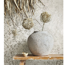 Dekorative Tapete mit Blumenmuster, Vase und Trockenblumen auf einem Holztisch