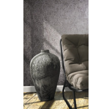 Dekorative Vase neben einem Stuhl vor gemusterter Tapete