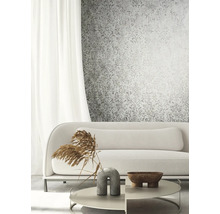 Wohnzimmer mit gemusterter Tapete, Sofa, Tisch und Dekoration