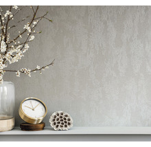 Nahaufnahme einer Wandtapete mit abstrakter Textur, kombiniert mit einer Vase, einer Uhr und einer Lotusblume auf einem Regal
