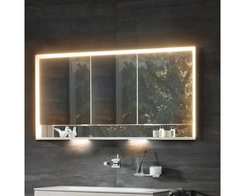 Armoire de toilette éclairée dans une salle de bains avec étagère pour les articles de toilette.