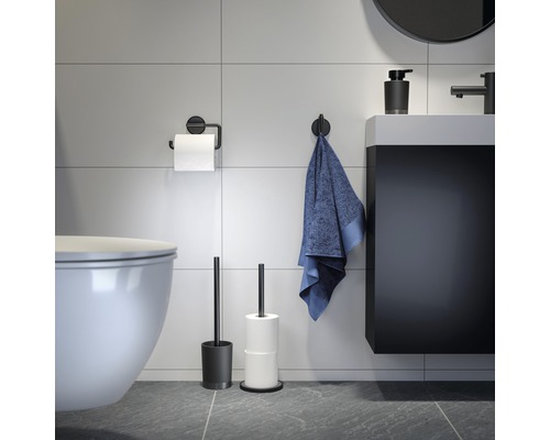 Modernes Badezimmer mit Toilette, Waschbecken, Handtuch, Toilettenpapierhalter, Toilettenbürste und Seifenspender
