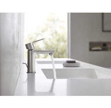 Wasserhahn aus Metall mit fließendem Wasser in einem hellen Badezimmer