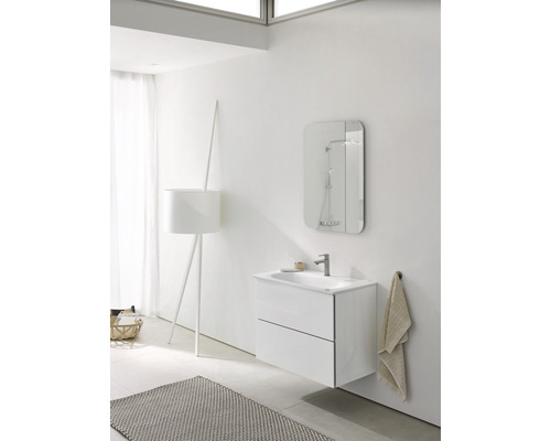 Salle de bains moderne avec lavabo, miroir, lampe et tapis pour une ambiance claire et organisée.