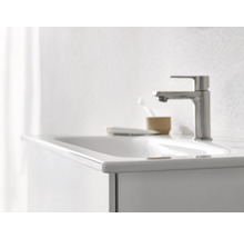 Detailansicht eines Waschbeckens mit Armatur, Seifenschale und Zahnputzbecher im Badezimmer