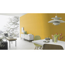Heller Wohnraum mit gelber Wand, Sideboard und Esstisch.