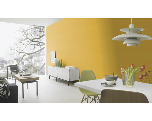 Heller Wohnraum mit gelber Wand, Sideboard und Esstisch.