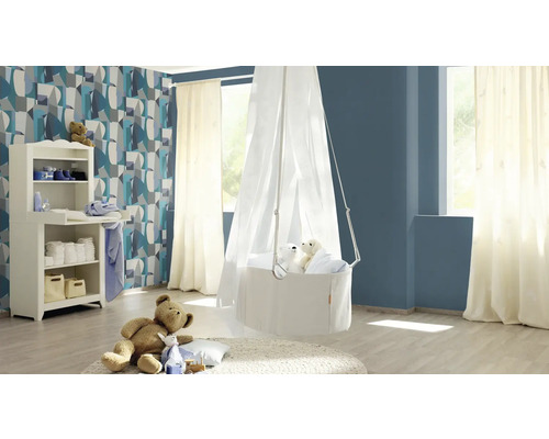 Ein Kinderzimmer mit Wickelkommode, Hängekörbchen mit Baldachin und Dekorationsartikeln.