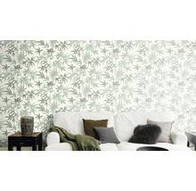 Salon avec canapé et papier peint à motifs de feuilles