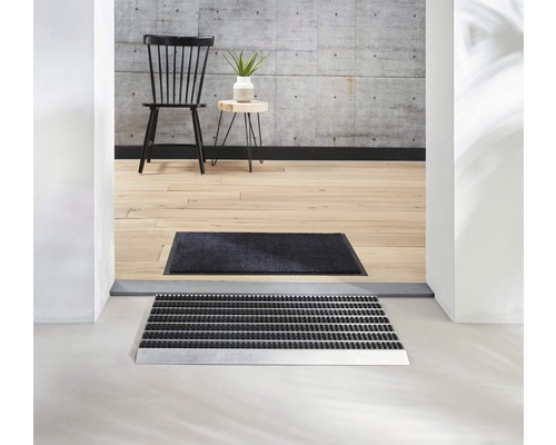 Scène avec paillasson et tapis de propreté devant une entrée de maison
