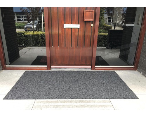 Paillasson gris devant une porte d''entrée