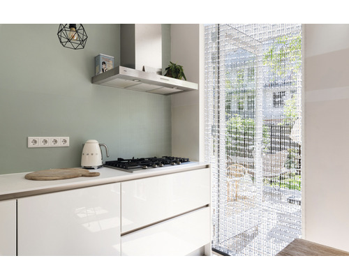 Cuisine moderne avec plaque de cuisson, hotte aspirante, rideau de perles et ustensiles de cuisine.