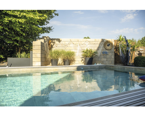 Piscine avec mur de pierre, jardinières et décoration maritime dans le jardin